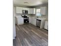 This modern kitchen features stainless steel appliances, white cabinets, and laminate floors at 736 Lawndale Cir, Fort Lawn, SC 29714