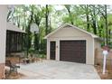 Detached garage with basketball hoop, seating area, and a pedestrian door, perfect for workshop at 7626 Surreywood Pl, Charlotte, NC 28270