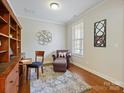Cozy home office featuring hardwood floors, natural light, and functional built-in shelving at 8618 Whitehawk Hill Rd, Waxhaw, NC 28173