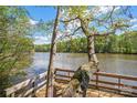 Scenic lake view from a wooden dock with mature trees and a serene waterfront atmosphere at 902 Cornelius Rd, Mooresville, NC 28117
