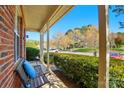 Inviting covered front porch featuring a bench and views of the manicured neighborhood at 9036 Four Mile Creek Rd, Charlotte, NC 28277