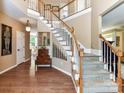 Spacious foyer featuring hardwood flooring, staircase, and stylish decor leading to other rooms at 9427 Bethesda Ct, Matthews, NC 28104
