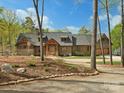 Stunning exterior of a wood-paneled home with stone accents and a well-manicured front yard at 111 Milledge Dr, Mooresville, NC 28117