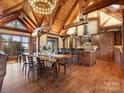 Open-concept living area featuring exposed beams, hardwood floors, and a large dining table at 111 Milledge Dr, Mooresville, NC 28117