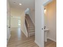 Inviting entryway with wood-look flooring, a staircase, and a convenient half-bathroom on the main floor at 1121 Red River Dr, Salisbury, NC 28144