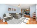 Inviting living room featuring a large sectional sofa, hardwood floors, and a ceiling fan, open to dining area at 114 Rolling Stone Ct, Mooresville, NC 28117