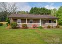 Inviting brick home featuring a long covered porch and a well-manicured lawn at 1663 Smyre Farm Rd # 5, Newton, NC 28658