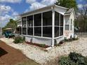 Well-kept manufactured home with a screened porch, accented by landscaped surroundings and a golf cart nearby at 171 Grand View Dr, New London, NC 28127