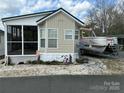 Quaint manufactured home featuring neutral siding, awning windows, and adjacent boat with trailer at 171 Grand View Dr, New London, NC 28127