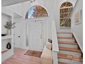 Bright entryway with hardwood floors, arched window above the front door, and staircase leading to upper level at 181 Glynwater Dr, Mooresville, NC 28117