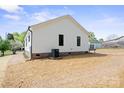 Rear view of a white home with brick foundation and compact air conditioning unit at 203 E 27Th St, Kannapolis, NC 28083