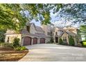 Elegant home with a three-car garage, stone accents, turret, and beautifully landscaped front yard at 20428 Island Forest Dr, Cornelius, NC 28031