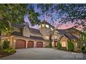 Elegant home with a three-car garage, stone accents, turret, and beautifully landscaped front yard at 20428 Island Forest Dr, Cornelius, NC 28031