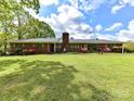 Charming brick home featuring a lush green lawn and meticulously landscaped front yard with mature trees at 225 Enwood Dr, Charlotte, NC 28214