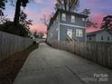 Rear view of the home showing the long driveway, partial fence, and two-story design at 2315 Dundeen St, Charlotte, NC 28216
