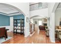 Open foyer with hardwood floors, staircase, and an archway leading into the living room at 2425 Orofino Ct, Charlotte, NC 28269