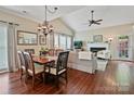 Open-concept living and dining area with hardwood floors, fireplace, and a vaulted ceiling at 2516 Middlebridge Ln, Charlotte, NC 28270