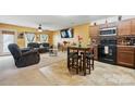 Open-concept living area with a dining table, ceiling fan, and large television at 3944 Hemingway Nw Dr, Hickory, NC 28601