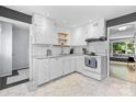 Bright kitchen featuring white cabinets, subway tile backsplash, stainless steel appliances, and hexagonal tile floor at 4607 Hedgemore Dr # D, Charlotte, NC 28209