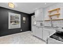 Updated kitchen with white cabinets, black walls, granite counters, and hexagonal tile flooring at 4607 Hedgemore Dr # D, Charlotte, NC 28209