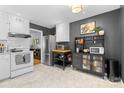 Spacious kitchen with stainless steel appliances, black accent wall, and decorative shelving with marble tile floors at 4607 Hedgemore Dr # D, Charlotte, NC 28209