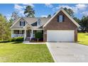 Charming brick and siding home featuring a two-car garage and inviting front porch with a manicured lawn at 5108 Boardwalk Ct, Dallas, NC 28034