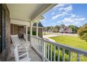 Inviting front porch with white rocking chairs provides a relaxing space to enjoy the neighborhood view at 5108 Boardwalk Ct, Dallas, NC 28034