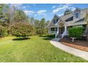 Beautifully landscaped front yard featuring lush green grass, mature trees, and a charming walkway to the front door at 5108 Boardwalk Ct, Dallas, NC 28034