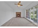 Cozy living room with a classic brick fireplace and large windows offering natural light at 70 Liberty Church Rd, Taylorsville, NC 28681