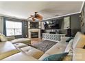 Bright living room with a fireplace, ceiling fan, large TV, and comfortable, contemporary seating at 7024 Sunman Rd, Charlotte, NC 28216