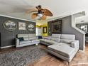 Stylish living room with gray brick accent wall, modern furniture, and unique ceiling fan at 7024 Sunman Rd, Charlotte, NC 28216