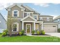 Charming two-story home featuring a well-maintained lawn, neutral siding, and a welcoming front porch with white trim at 8715 Gladden Hill Ln, Fort Mill, SC 29715