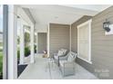 Inviting front porch with two chairs and a small table, perfect for relaxing outdoors at 8715 Gladden Hill Ln, Fort Mill, SC 29715