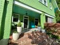 Inviting covered front porch with red brick steps, swing, and plants, providing a cozy outdoor space at 1000 Margaret Brown St, Charlotte, NC 28202