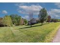 A spacious, grassy backyard with scattered trees and a partial view of the house at 106 Zurich Ln, Statesville, NC 28625