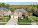 Aerial view of a brick home featuring a well-manicured lawn with mature trees at 10643 Rippling Stream Nw Dr, Concord, NC 28027