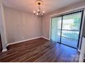 Bright dining area with wood floors, a chandelier, and sliding door access to the outside at 11015 Harrowfield Rd, Charlotte, NC 28226
