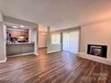 Inviting living room featuring wood floors, a brick fireplace, and ample natural light at 11015 Harrowfield Rd, Charlotte, NC 28226
