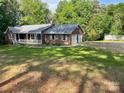Brick house with a two-car garage and a well-maintained lawn with mature trees at 1300 Irish Potato Rd, Concord, NC 28025