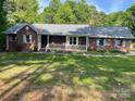 Brick home with a cozy front porch and manicured landscaping, creating a warm curb appeal at 1300 Irish Potato Rd, Concord, NC 28025