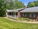 A well-kept brick home with a welcoming front porch, complemented by landscaped surroundings at 1300 Irish Potato Rd, Concord, NC 28025