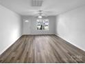 Spacious living room with a ceiling fan, luxury vinyl plank flooring, and ample natural light at 1325 Crandon Dr, Charlotte, NC 28216