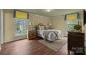 Cozy bedroom with hardwood floors, a comfortable bed, and ample natural light from two windows at 1676 Partridge Cir, Lancaster, SC 29720
