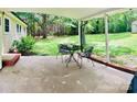 Relaxing covered back porch with a metal table and chairs overlooking a lush backyard at 1780 Short St, Mount Pleasant, NC 28124