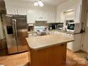 Bright kitchen with white cabinets, stainless steel refrigerator, and center island at 1780 Short St, Mount Pleasant, NC 28124