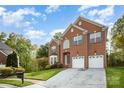 Brick two-story house with a two-car attached garage, driveway, and well-manicured front yard with mature trees at 1801 Briarcrest Nw Dr, Charlotte, NC 28269
