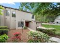 Charming townhome showing vibrant landscaping, exterior lighting, red front door, and lush greenery at 181 Riverview Ter, Clover, SC 29710