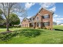 Spacious brick home with a large front yard, lush green lawn, and mature tree at 2003 Ptarmigan Ct, Waxhaw, NC 28173