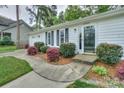 Close up of a charming home entrance with a well-maintained lawn and meticulously landscaped yard at 22025 Torrence Chapel Rd, Cornelius, NC 28031