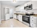 Kitchen featuring white cabinets, stainless steel appliances, granite countertops, and tile flooring at 2815 Grimes St, Charlotte, NC 28206